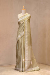 Close up of Matte Olive Green Tussar Silk Saree showing printed flying crane motifs and resham woven floral Parsi border.