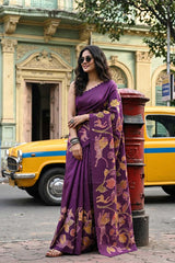 Woman in a purple tussar shikargha saree standing on a street with a yellow taxi and red postbox in the background.